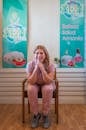 A woman sitting in a spa, smiling and promoting beauty, health, and harmony.