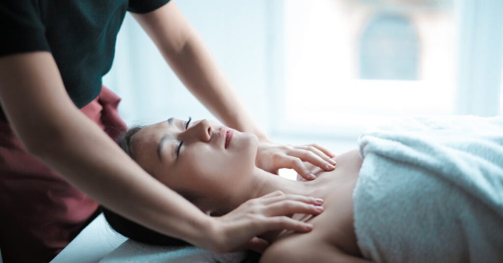 A serene spa massage session with a woman relaxing on a table, receiving a calming neck massage.